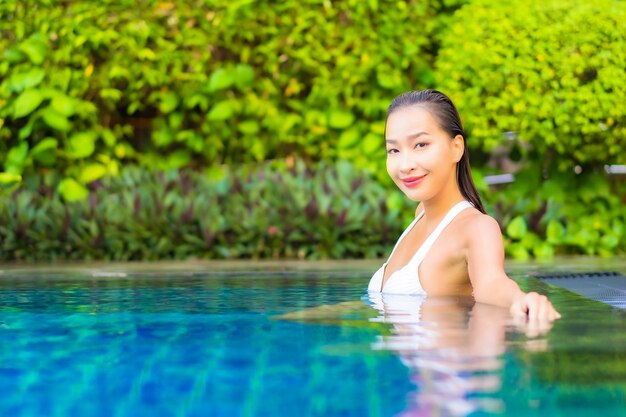 휴가에 리조트 호텔의 수영장 주변에서 휴식을 취하는 아름다운 젊은 아시아 여성 초상화
