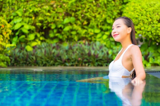 Portrait beautiful young asian woman relaxing around swimming pool in resort hotel on vacation