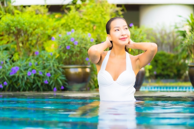 Portrait beautiful young asian woman relaxing around swimming pool in resort hotel on vacation