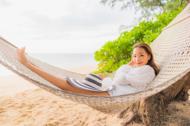 Portrait of beautiful young asian woman relaxing on hammock around beach in vacation