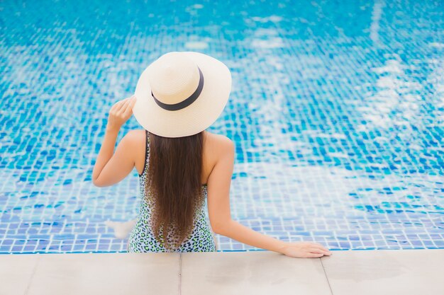 Женщина портрета красивая молодая азиатская расслабляющая открытый в бассейне в отпуске