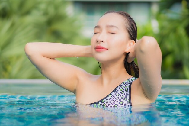 Женщина портрета красивая молодая азиатская расслабляющая открытый в бассейне в отпуске