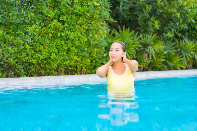 Портрет красивой молодой азиатской женщины, расслабляющейся в бассейне