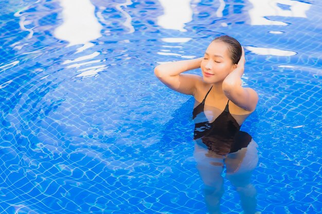 호텔 리조트에서 야외 수영장 주변에서 편안한 아름 다운 젊은 아시아 여자의 초상화