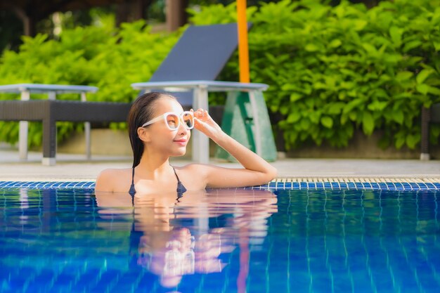 Portrait of beautiful young asian woman relaxinging around outdoor swimming pool in hotel resort