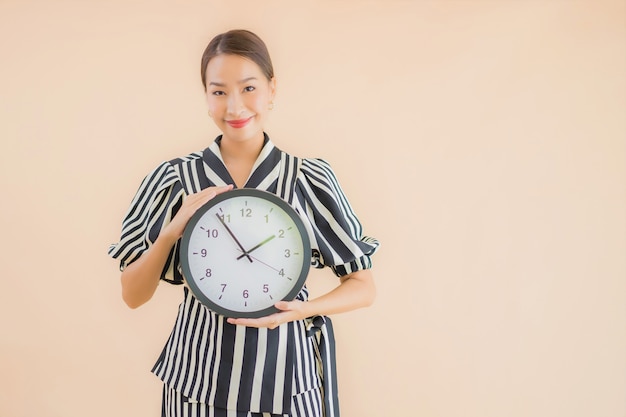 美麗的年輕亞洲女子的肖像顯示鐘或鐘