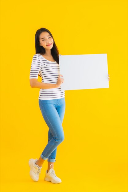 肖像画の美しい若いアジア女性は空の白い看板サインを表示します。
