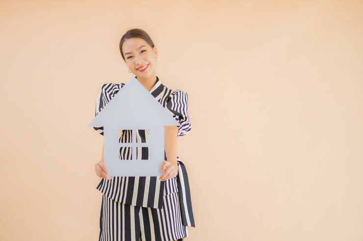 無料Photo 肖像画の美しい若いアジア女性は家や家の紙の看板を表示します。