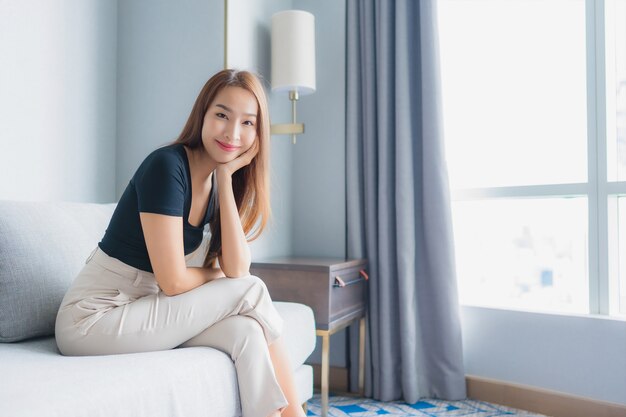 Portrait beautiful young asian woman sit on sofa relax in living room area