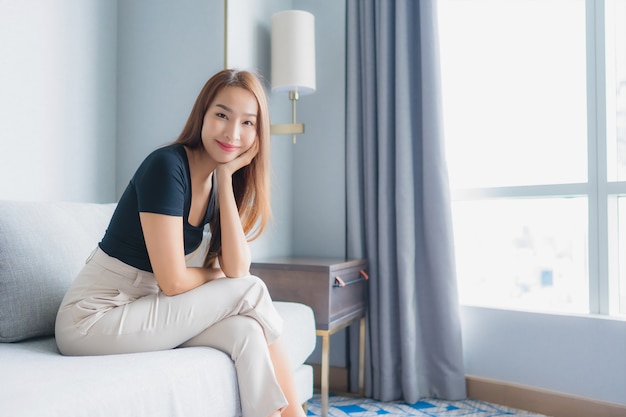 Portrait beautiful young asian woman sit on sofa relax in living room area