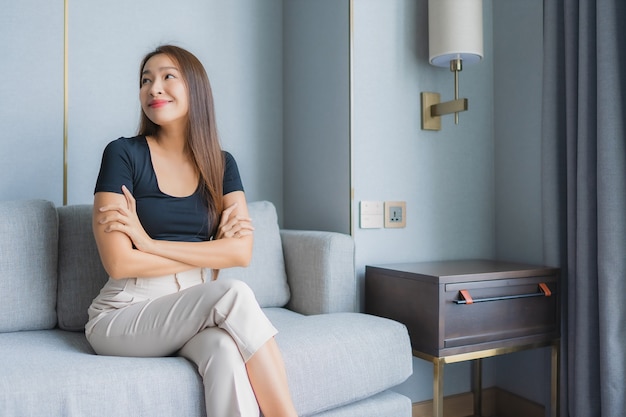 Portrait beautiful young asian woman sit on sofa relax in living room area