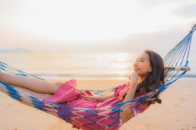 笑顔幸せなニアリービーチ海とoceでハンモックに座っている肖像画