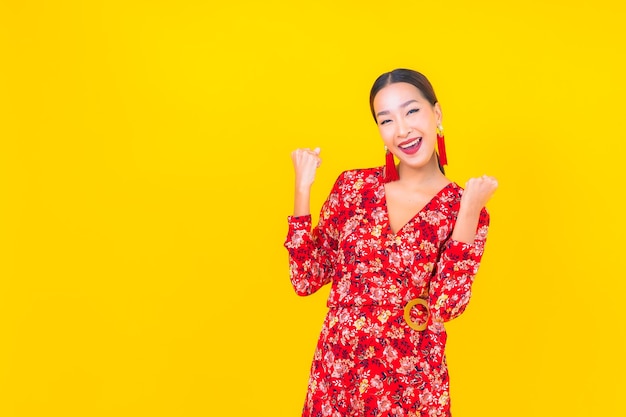 세로 아름 다운 젊은 아시아 여자 컬러 벽에 중국 새 해 개념에서 행동에 미소