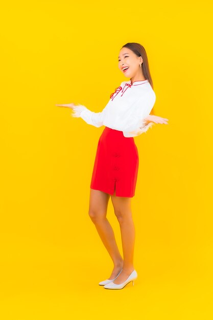 Portrait beautiful young asian woman smile in action on yellow