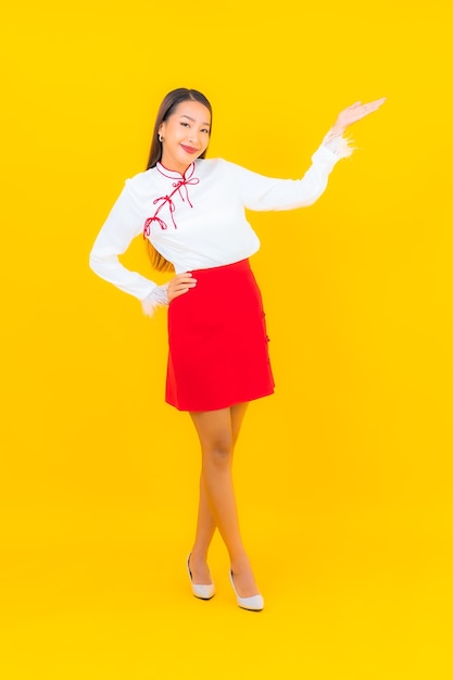 Portrait beautiful young asian woman smile in action on yellow