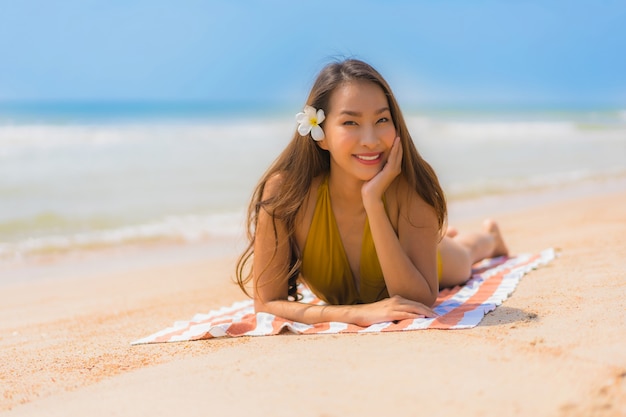 초상화 아름 다운 젊은 아시아 여자는 해변과 바다에 행복 미소