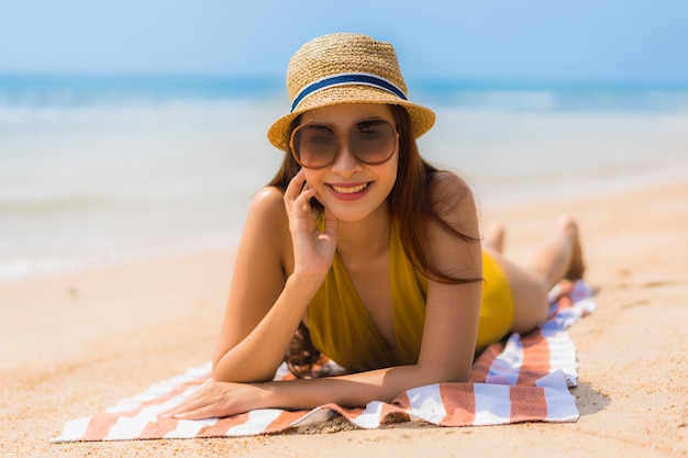 Foto gratuita ritratto bella giovane donna asiatica sorriso felice sulla spiaggia e sul mare