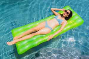 Бесплатное фото Улыбка женщины портрета красивая молодая азиатская счастливая ослабляет и отдыхает в бассейне