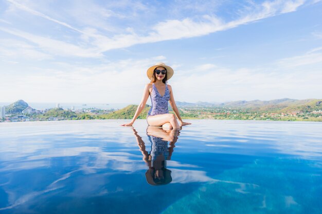 Portrait beautiful young asian woman smile happy relax around swimming pool in hotel resort for leisure