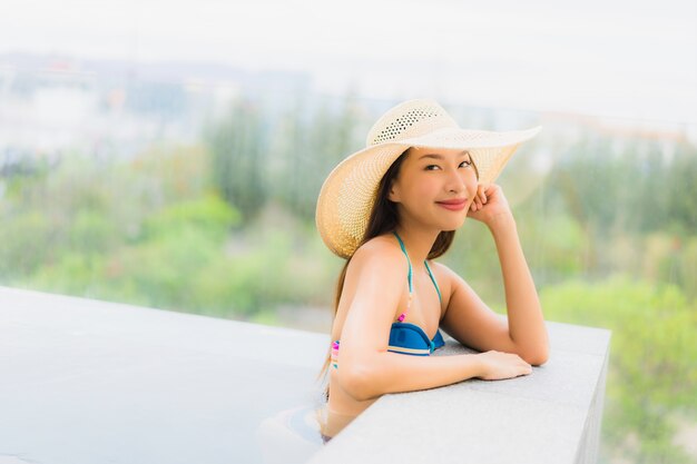 초상화 아름 다운 젊은 아시아 여자 미소 행복 레저 호텔 리조트 수영장 주위 휴식