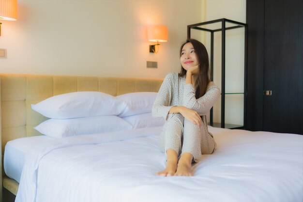 Portrait beautiful young asian woman smile happy relax on bed