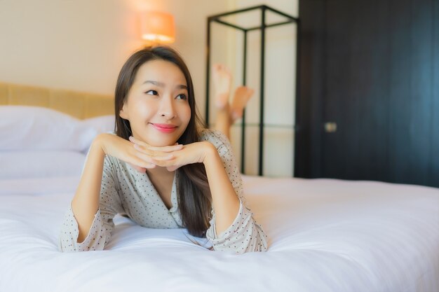 Portrait beautiful young asian woman smile happy relax on bed