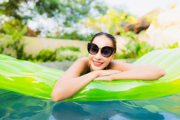 Portrait beautiful young asian woman smile happy relax and leisure in the swimming pool