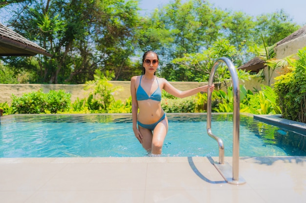 Portrait beautiful young asian woman smile happy relax and leisure in the swimming pool