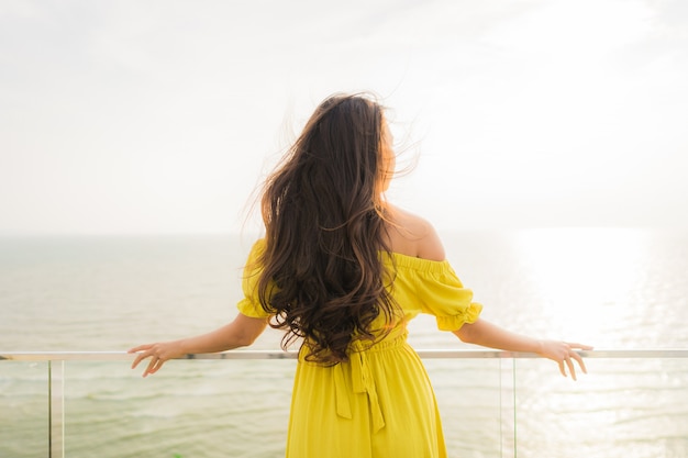 Portrait beautiful young asian woman smile happy and relax at outdoor balcony with sea beach and oce