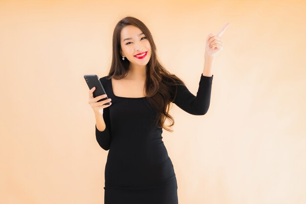 肖像画の美しい若いアジアの女性の笑顔幸せな使用スマート携帯電話