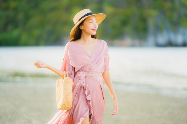 Portrait beautiful young asian woman smile happy walk on the tropical outdoor nature beach sea