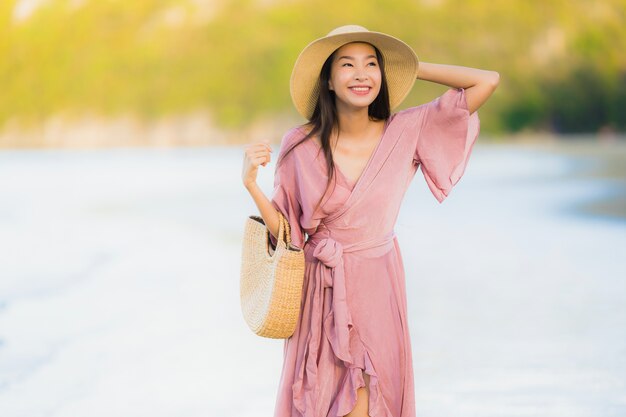 Portrait beautiful young asian woman smile happy walk on the tropical outdoor nature beach sea