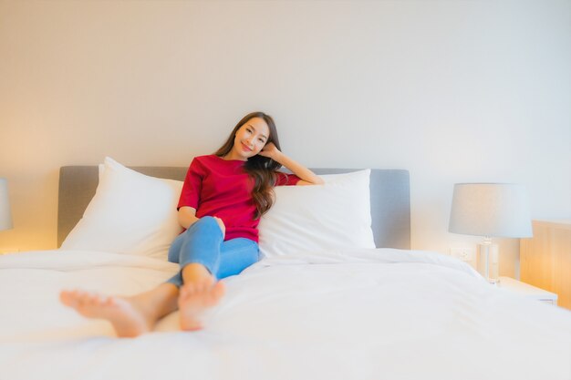 Portrait beautiful young asian woman smile relax on bed