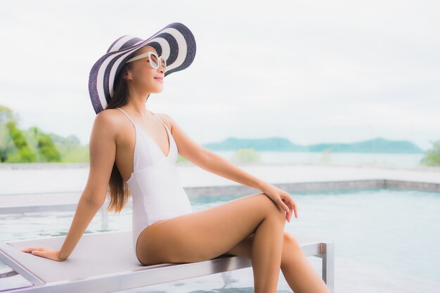 Portrait beautiful young asian woman smile relax and leisure around outdoor swimming pool