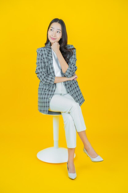 색 배경에 행동으로 미소 짓는 아름다운 젊은 아시아 여성 초상화