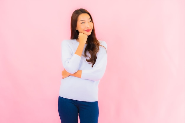 Portrait beautiful young asian woman smile with action on pink isolated wall