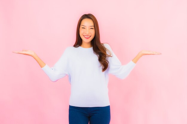 초상화 아름 다운 젊은 아시아 여자 핑크 절연 벽에 행동과 미소