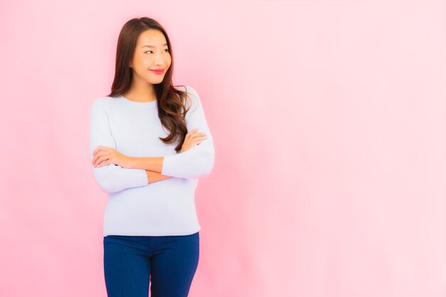 Portrait beautiful young asian woman smile with action on pink isolated wall