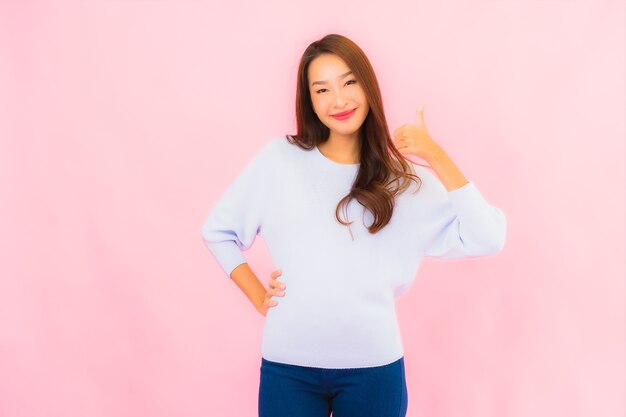 Portrait beautiful young asian woman smile with action on pink isolated wall