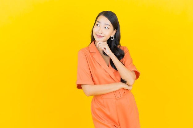 Portrait beautiful young asian woman smile with action on yellow