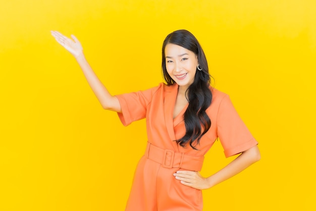 노란색에 행동과 초상화 아름 다운 젊은 아시아 여자 미소