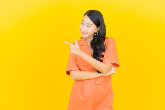 Portrait beautiful young asian woman smile with action on yellow