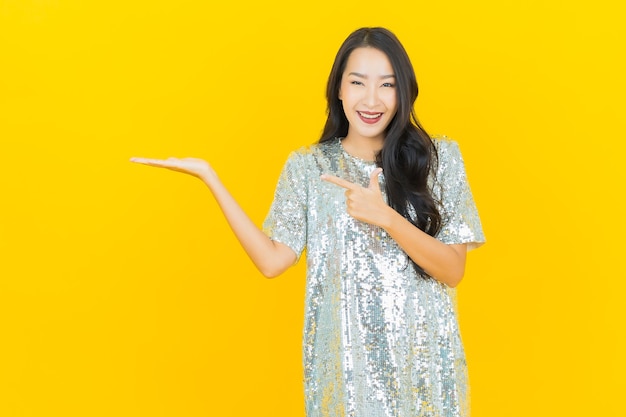 Portrait beautiful young asian woman smile with action on yellow