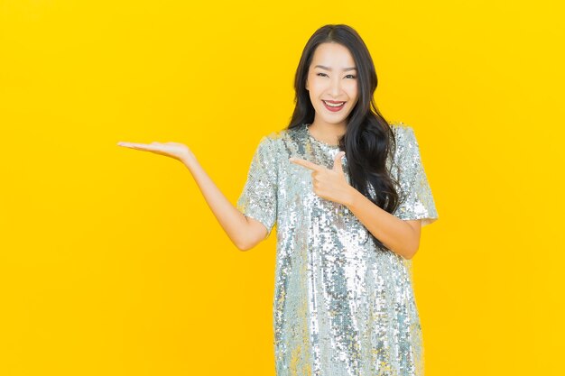 Portrait beautiful young asian woman smile with action on yellow