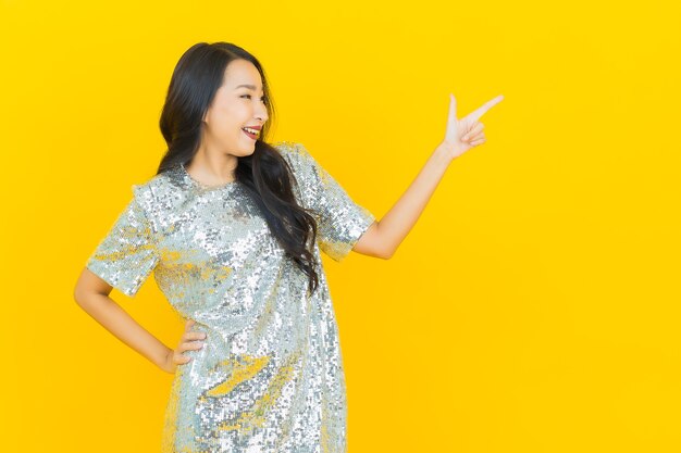 Portrait beautiful young asian woman smile with action on yellow