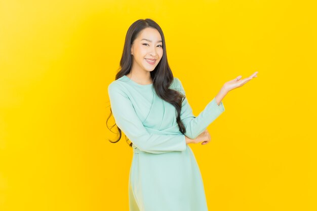 Portrait beautiful young asian woman smile with action on yellow