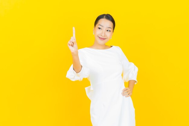 Portrait beautiful young asian woman smile with action on yellow