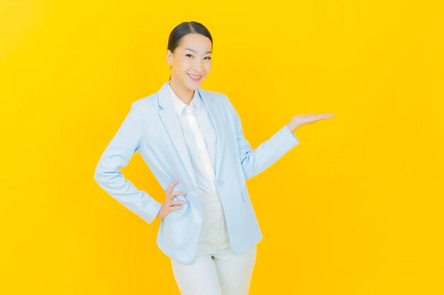 Portrait beautiful young asian woman smile with action on yellow