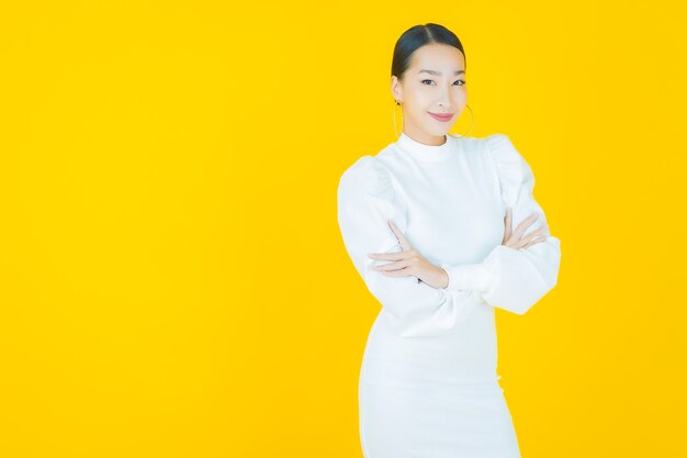 Portrait beautiful young asian woman smile with action on yellow