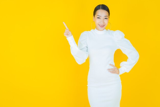 Portrait beautiful young asian woman smile with action on yellow